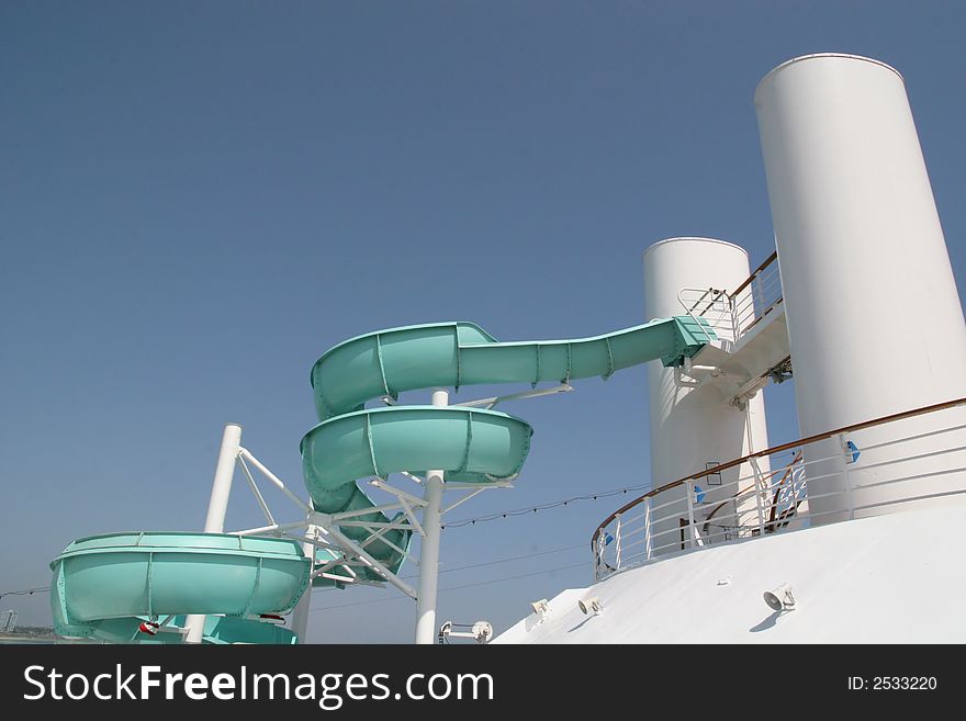 Green slide on a white ship against a blue sky