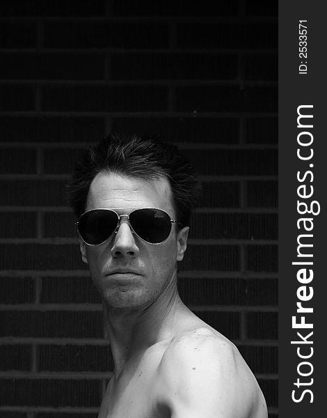 Adult male model portrait brick background black and white. Adult male model portrait brick background black and white