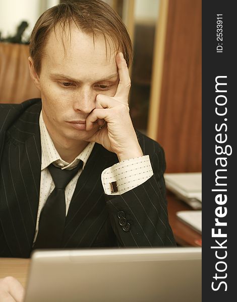 The businessman at office behind a computer