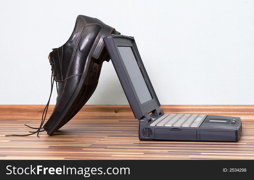 Man shoes standing near laptop. Man shoes standing near laptop