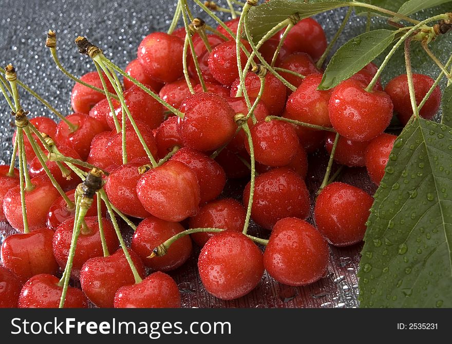 Red wet cherries with leaves close up shoot. Red wet cherries with leaves close up shoot