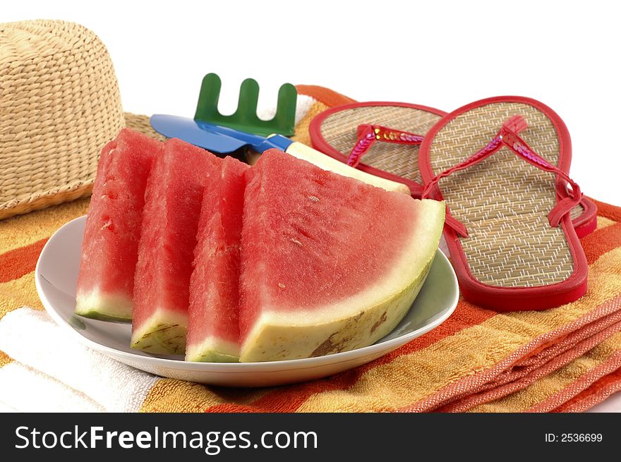Slices of fresh watermelon with towel and other beach items. Slices of fresh watermelon with towel and other beach items.