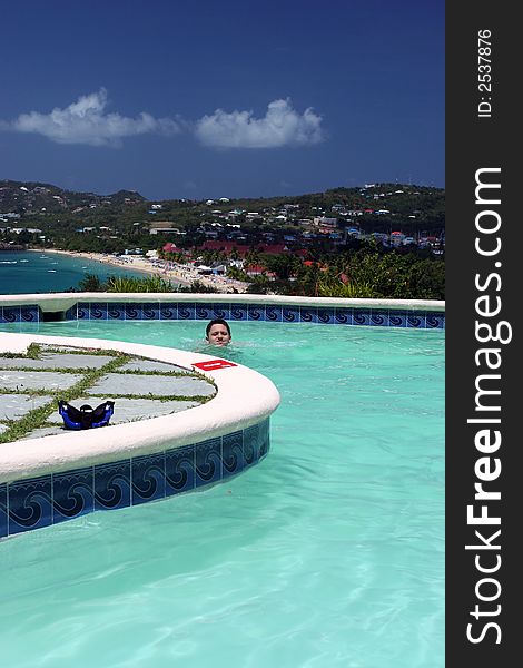 Boy swimming in pool with overlook to beautiful beach in Caribbean. Boy swimming in pool with overlook to beautiful beach in Caribbean