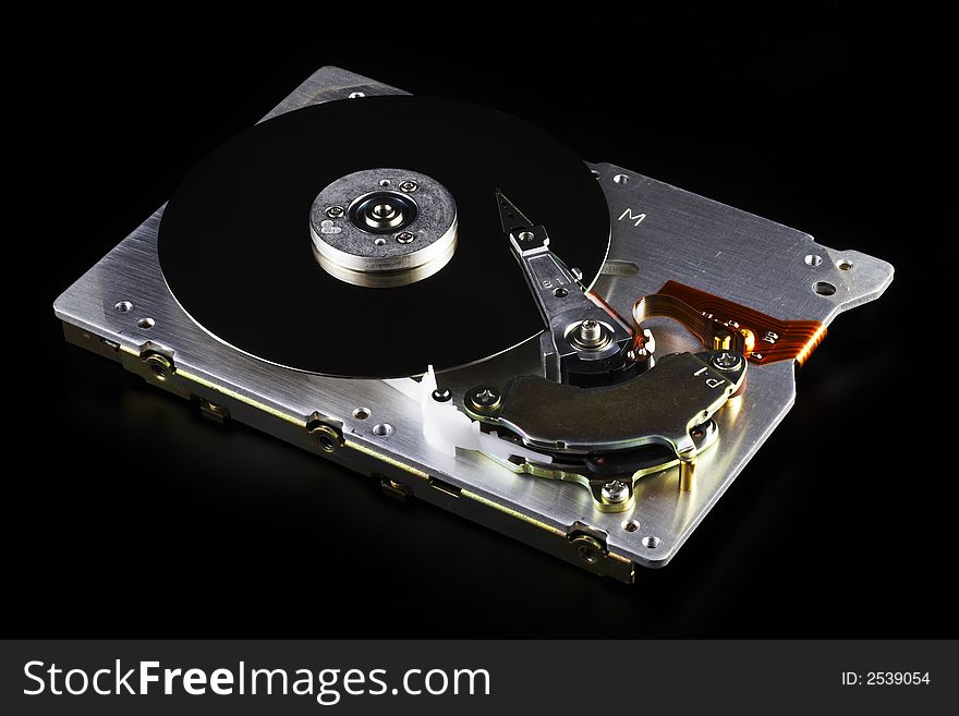 Opened 3,5 hard disk drive on a black background. Opened 3,5 hard disk drive on a black background