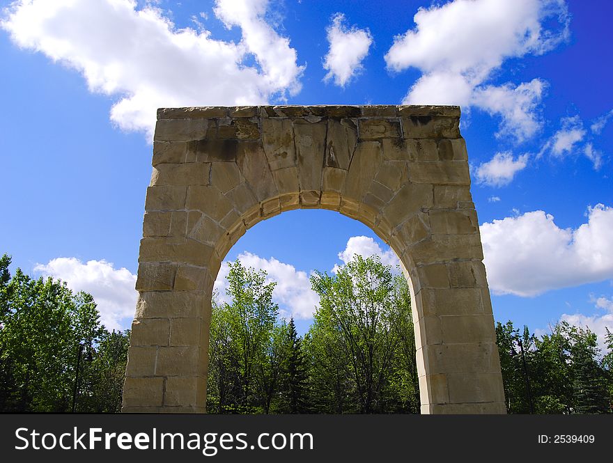 A stone arc at the park in sunny partially cloudy day. A stone arc at the park in sunny partially cloudy day