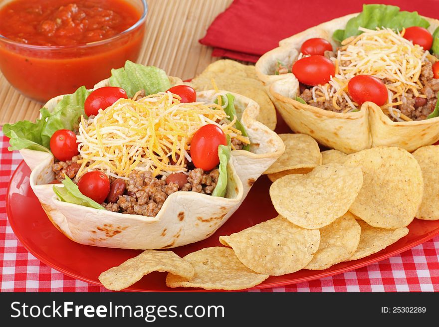 Taco salads in tortilla shells with chips and salsa