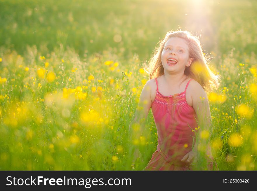 Sweet happy little girl with grass and sun