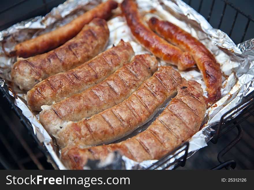 Sausages on the grill in a foil. Sausages on the grill in a foil