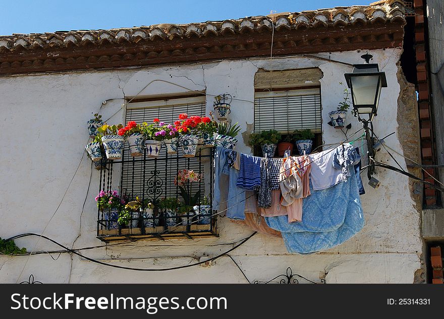 Hanging clothes and flowered balcony.