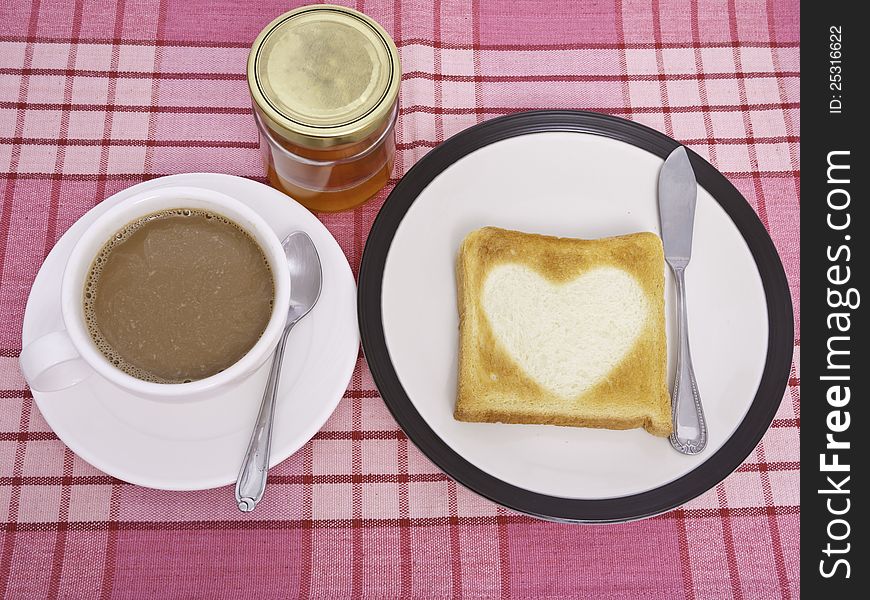 A cup of cofee and heart shaped toast. A cup of cofee and heart shaped toast