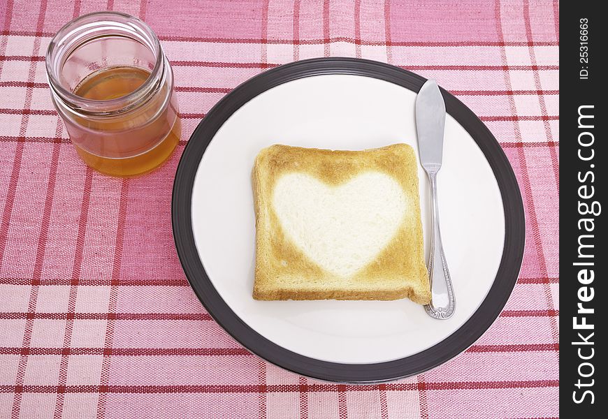 Heart-shaped toast on a dish and honey. Heart-shaped toast on a dish and honey