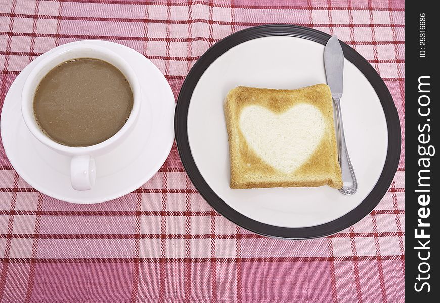 A cup of cofee and heart shaped toast. A cup of cofee and heart shaped toast
