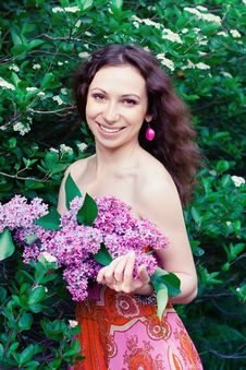 Woman With Lilac Flowers Stock Images