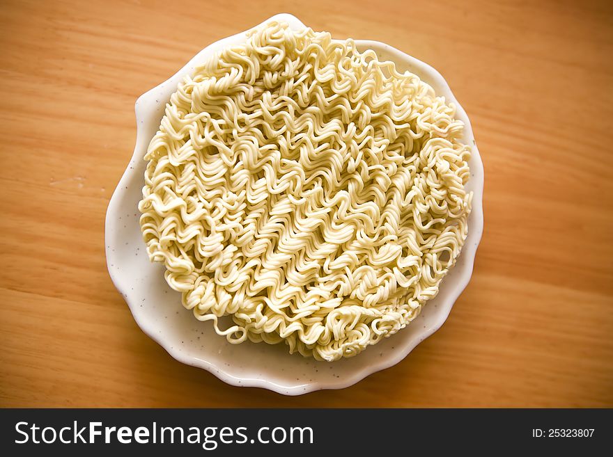 A block of dry instant ramen noodles in the dish