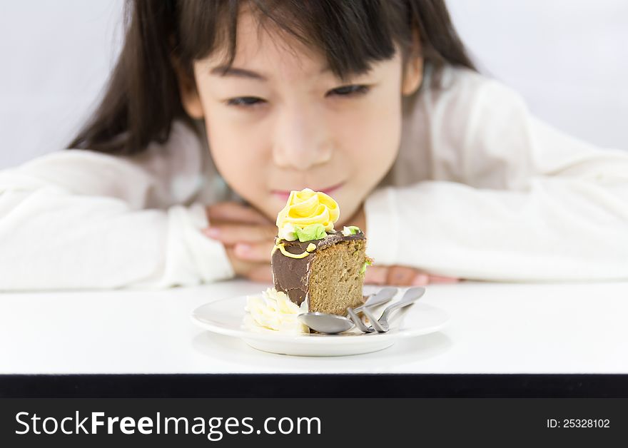 The girl stared cake for overcome by a temptation to eat a slice of a sweet cake