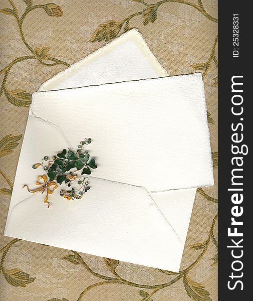 Paper sheet and envelope on textile with handmade shamrocks. Paper sheet and envelope on textile with handmade shamrocks