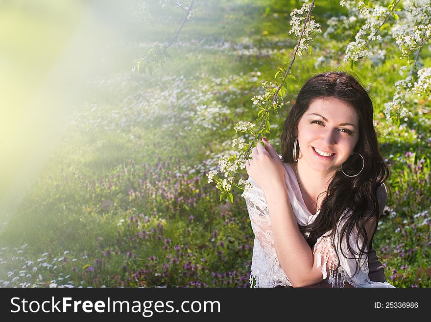 Image of a beautiful girl in the park against the backdrop of flowering trees