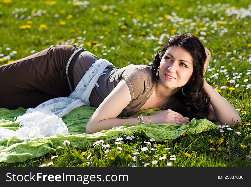 Beautiful girl lying on the grass with flowers