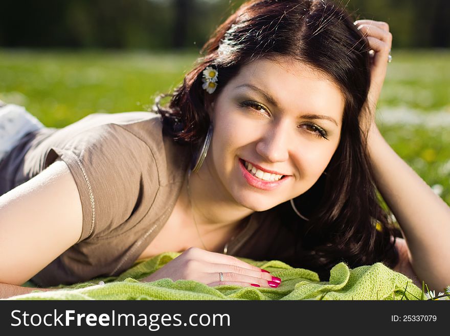 Beautiful girl lying on the plaid in the park