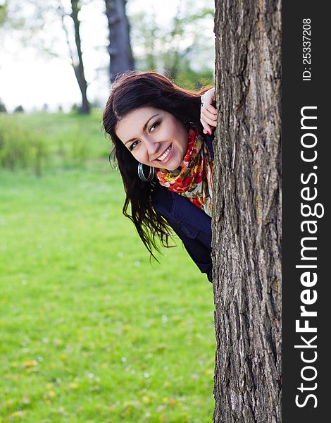 Beautiful young girl near tree