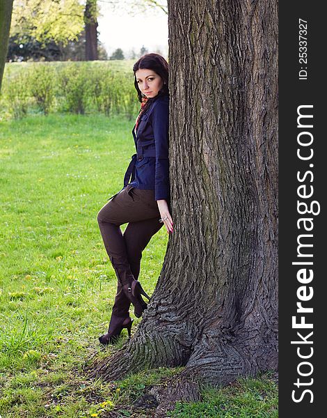 Beautiful young girl near tree in the park