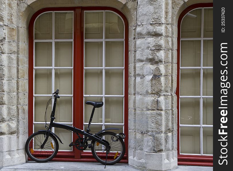 Bicycle standing against a wall under a window. Bicycle standing against a wall under a window