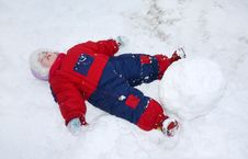 Little Tired Girl Lies On Snow Near Big Snowball Royalty Free Stock Image Little Tired Girl Lies On Snow Near Big Snowball Royalty Free Stock Image