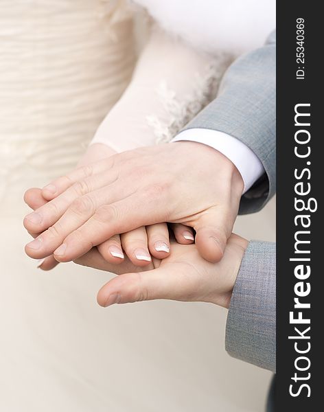 Man holding a fragile bride's hand in his strong arms. Man holding a fragile bride's hand in his strong arms