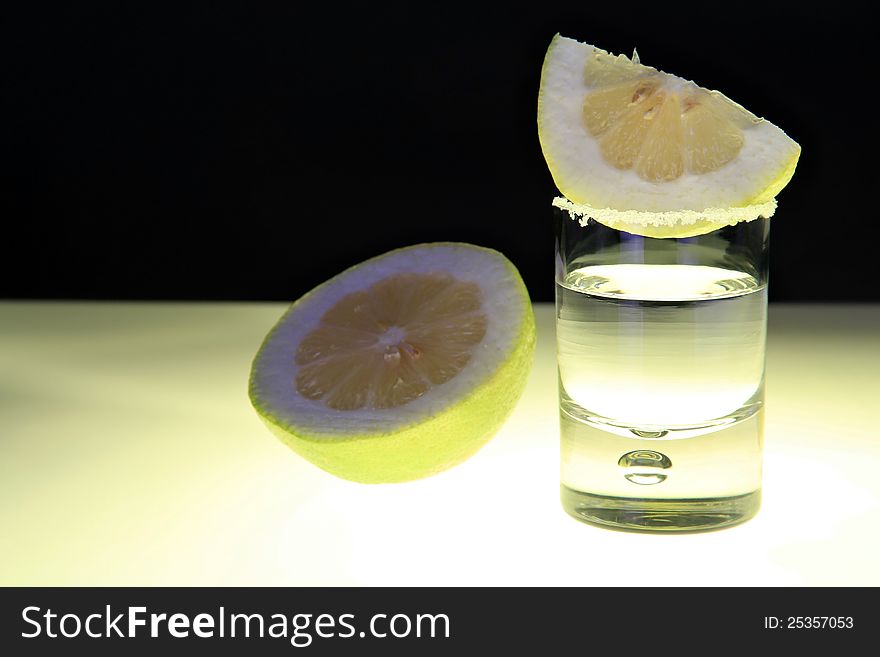 Glass of Tequila on bar table with salt and lemon slice. Glass of Tequila on bar table with salt and lemon slice.