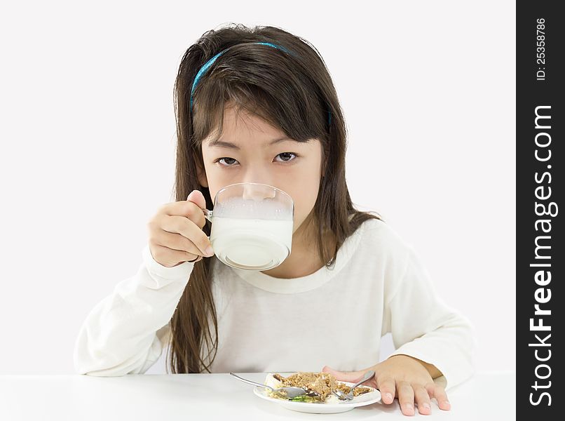 Cute girl drinking a glass of milk and eating a cake. Cute girl drinking a glass of milk and eating a cake