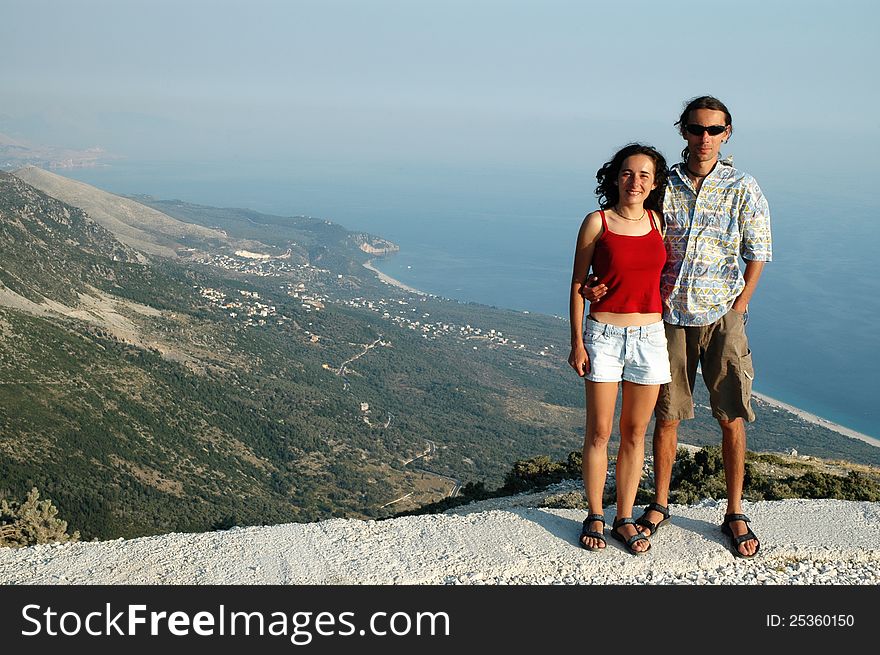 Romantic couple on a height, ocean in the background