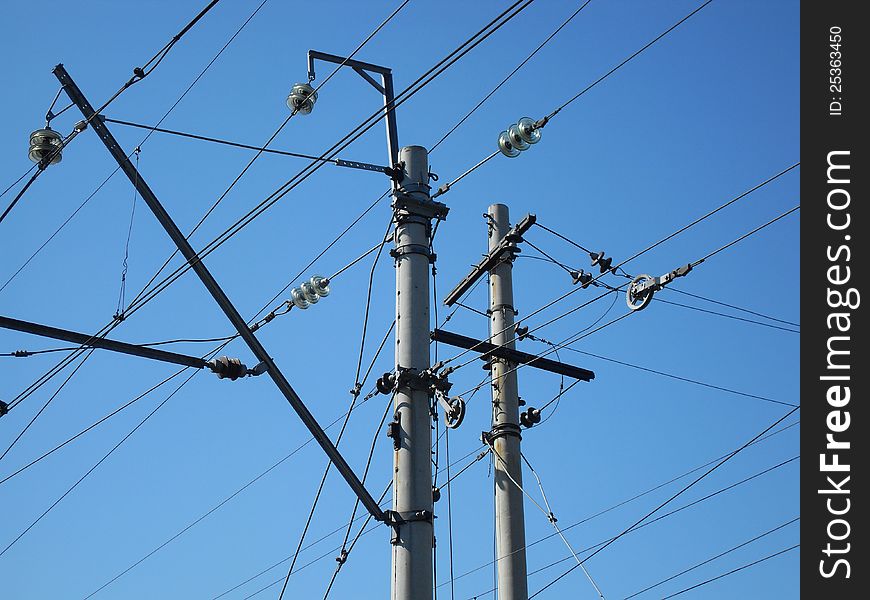 Electrical post with power line cables against blue sky.