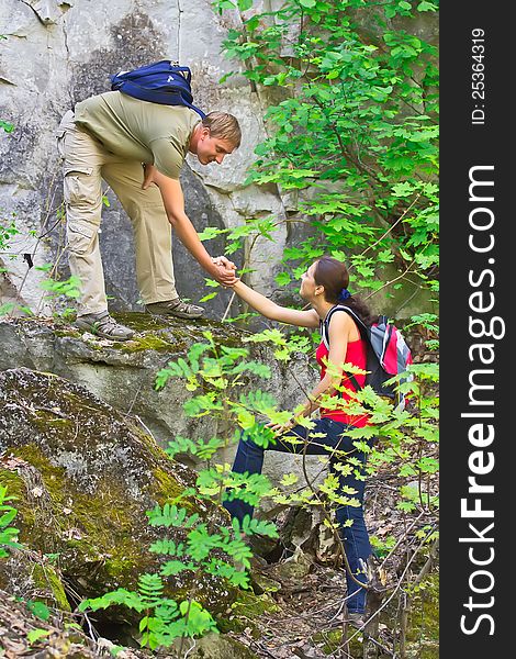 The young men helps the girl back to сскале. The young men helps the girl back to сскале