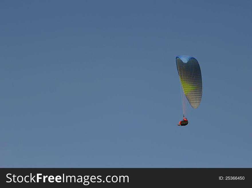A paraglider on a blue sky at a seaside