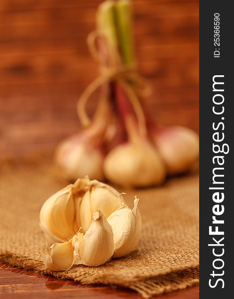 Summer garlic on burlap in rustic background