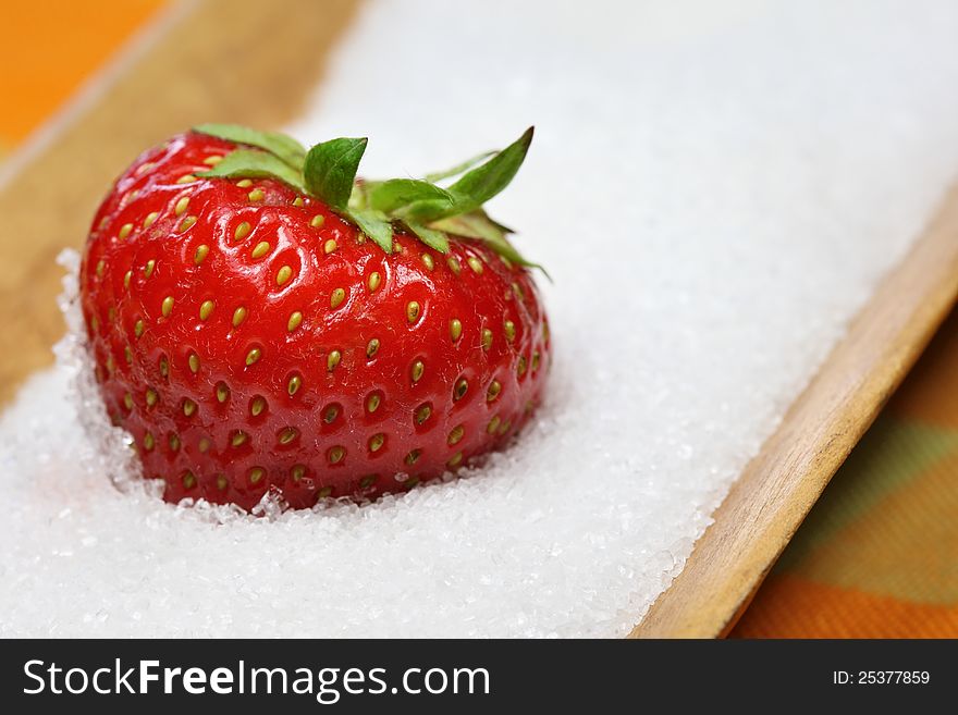 A strawberry is lying in sugar