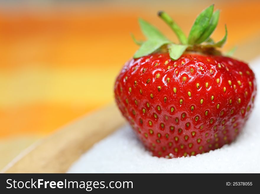 A strawberry is lying in sugar