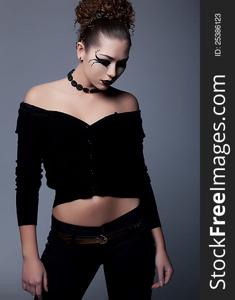 Young slim lady in black with creative makeup posing. Young slim lady in black with creative makeup posing