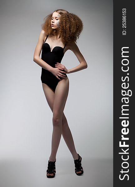 curly redhead girl with long legs over white background. curly redhead girl with long legs over white background