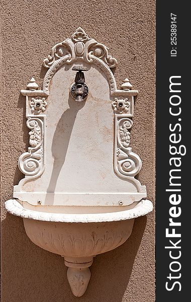 Decorative antique white wash basin hanging on the wall. Decorative antique white wash basin hanging on the wall