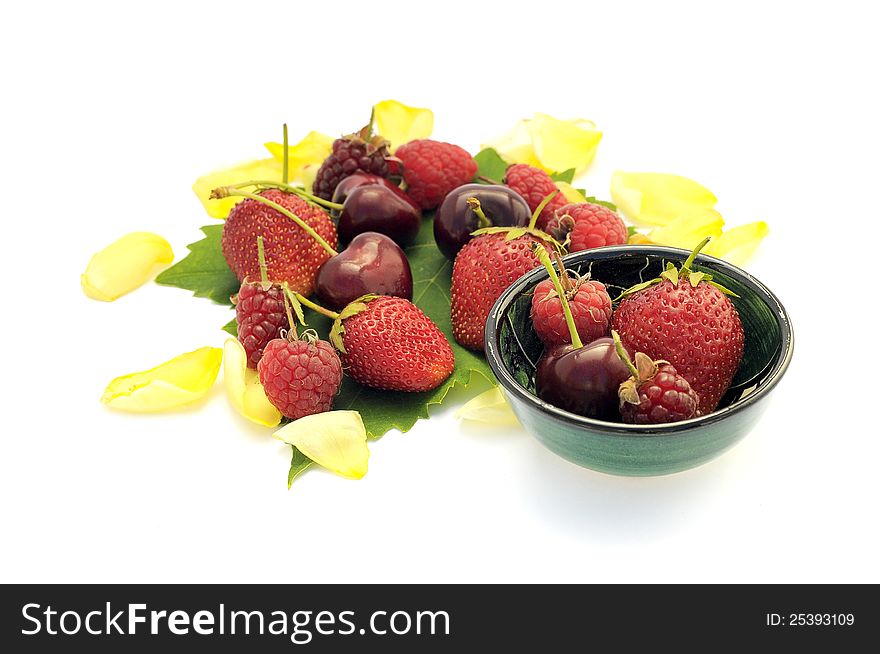 Some raspberries, strawberries, cherries on a leaf isolated on white. Some raspberries, strawberries, cherries on a leaf isolated on white