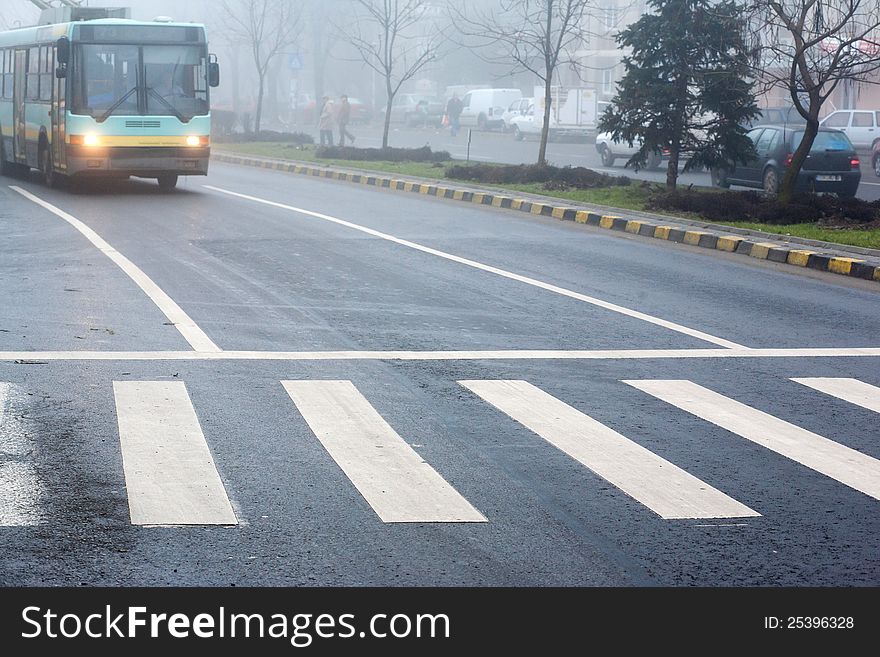 Crosswalk on a city street and trolley approaching. Crosswalk on a city street and trolley approaching