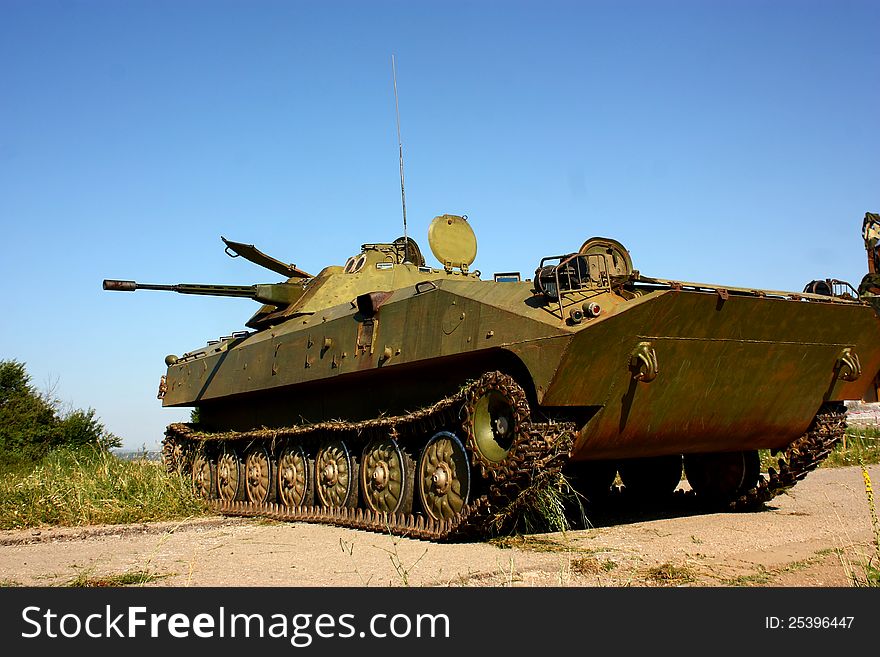 Military armored fighter vehicle of infantry (BMP-2) blocking a road with clear blue sky. Military armored fighter vehicle of infantry (BMP-2) blocking a road with clear blue sky