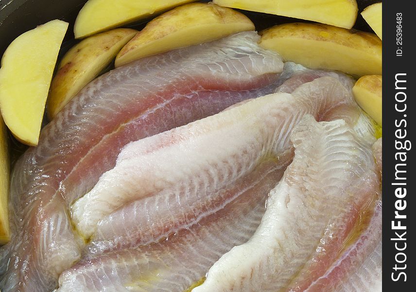 Pangasius fillets of raw fish ready for roasting with potatoes