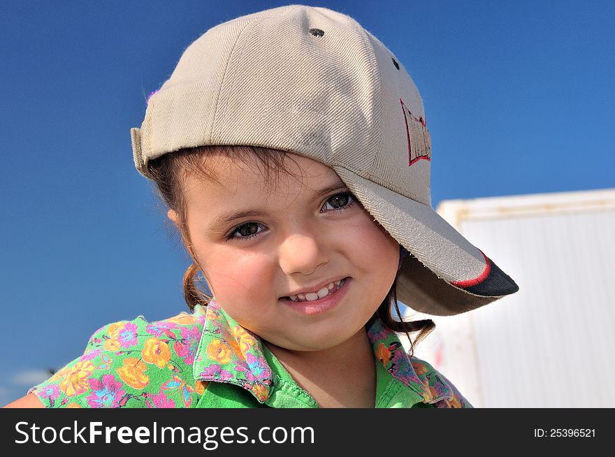 Little girl in my father's baseball cap with the number 911, posing for a photograph. Little girl in my father's baseball cap with the number 911, posing for a photograph