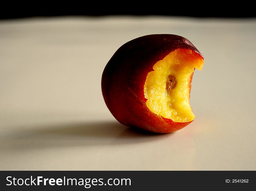 Bitten nectarine, on an empty table. Bitten nectarine, on an empty table