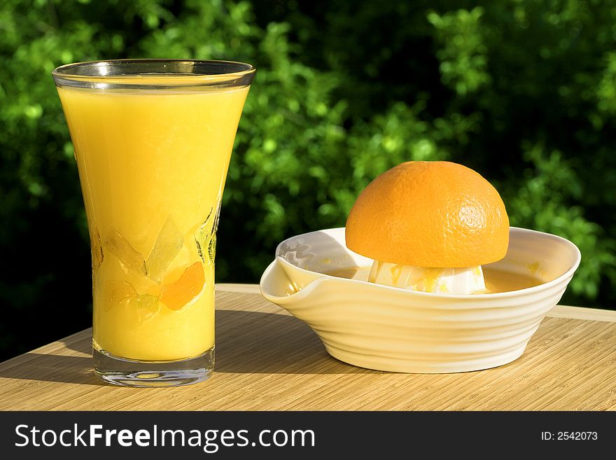 Glass Of Fresh Squeezed Organic Orange Juice - Juicer And Orange With Natural Outdoor Background