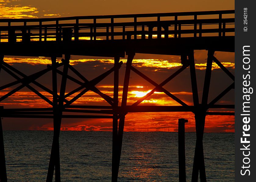 Taken in Southport, South Carolina, at bladly Island, a bueaitful sunset gleaming through a pier into the ocean. Taken in Southport, South Carolina, at bladly Island, a bueaitful sunset gleaming through a pier into the ocean.