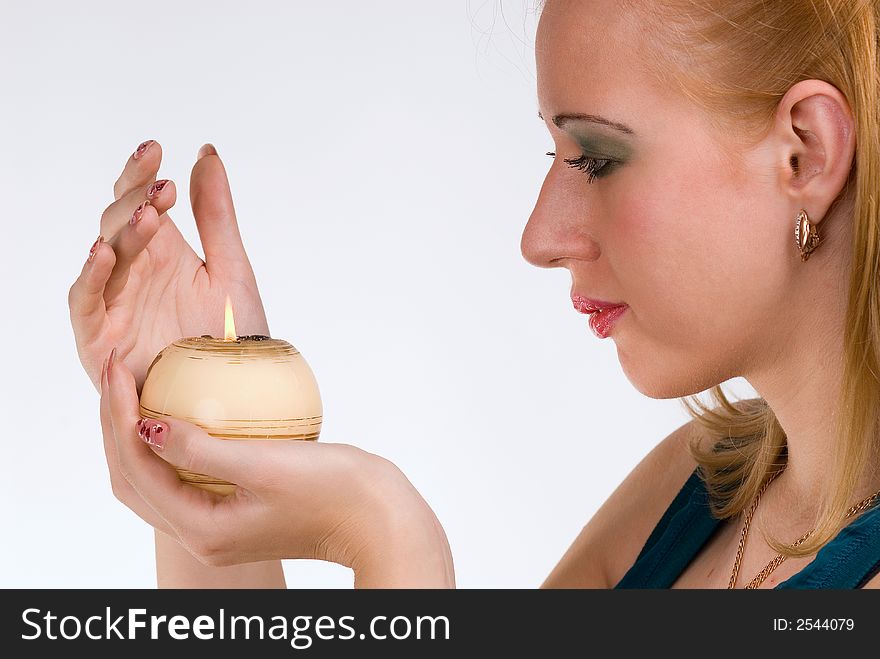The girl holds in a hand a candle on a white background. The girl holds in a hand a candle on a white background