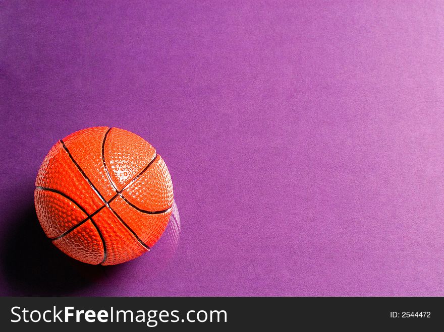 Basketball ball on glass with a violet background